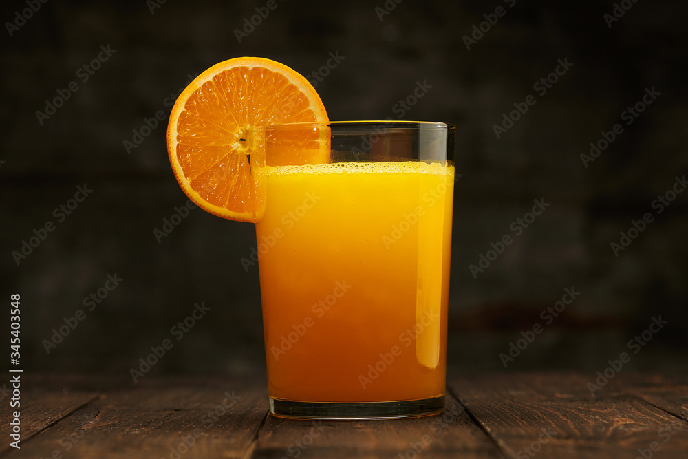 Fresh orange juice and fruit on a wooden table - natural and healthy food and drink. One glass of cocktail with a slice of fruit Fresh orange juice and fruit on a wooden table - natural and healthy food and drink. One glass of cocktail with a slice of fruit