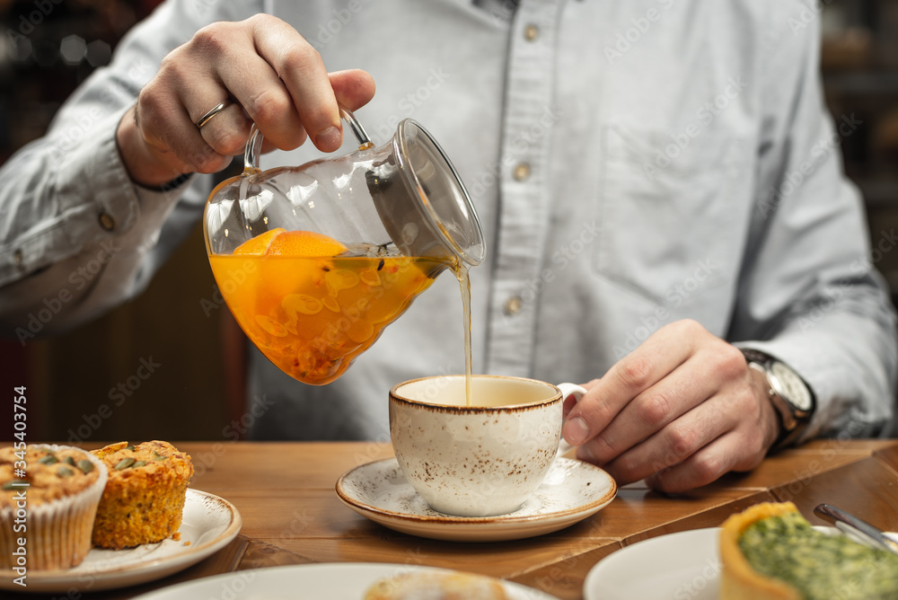 A man pours himself a tea drink. A man pours himself a tea drink.