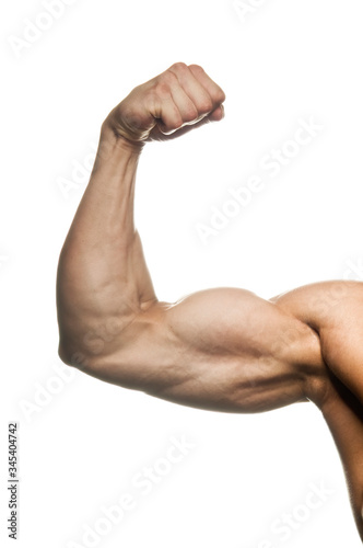 Close-up of a power fitness man's hand. Muscular bodybuilder flexing and showing his biceps - internal side - on white background. Studio shot
