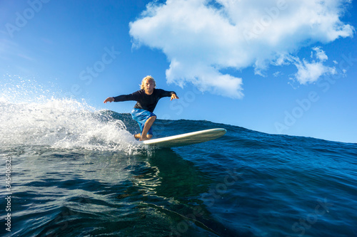 muscular surfer with long white hair riding on big waves on the Indian Ocean island of Mauritius © ohrim