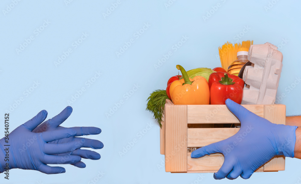 Delivery service worker in protective gloves hands over a set of products  to the customer receiving order from courier at home. Express delivery,  food delivery, online shopping concept Stock Photo | Adobe