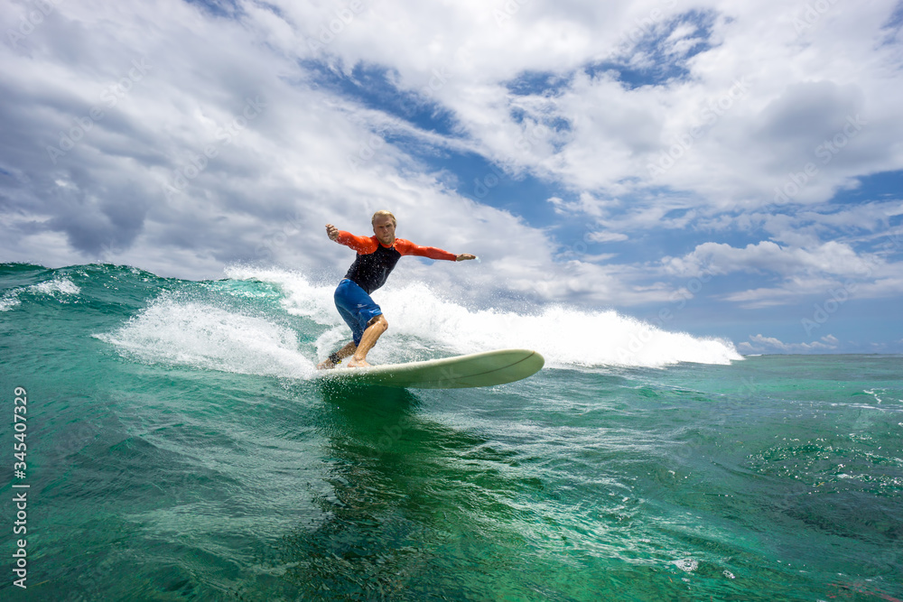 muscular surfer with long white hair riding on big waves on the Indian Ocean island of Mauritius