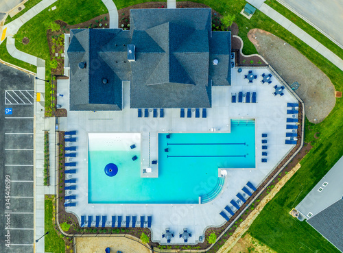 Aerial top down view of new construction American residential community clubhouse pool with beach chairs at a new development photo