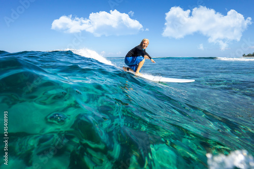muscular surfer with long white hair riding on big waves on the Indian Ocean island of Mauritius