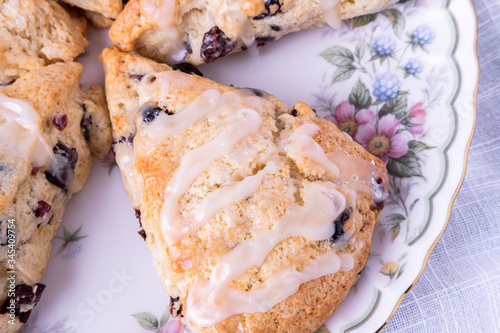 Close-up of Glazed Cranberry Orange Scones on a plate being prepared to serve guests