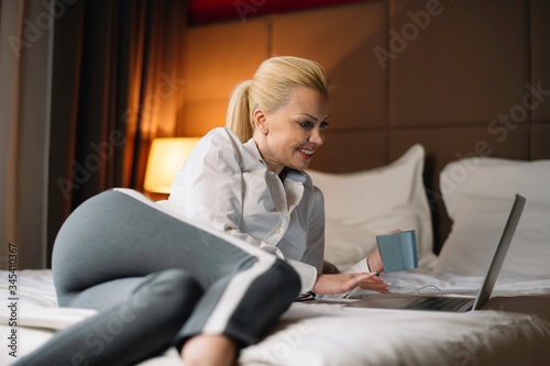 Young businesswoman working on lap top. Beautiful woman working in hotel room. 