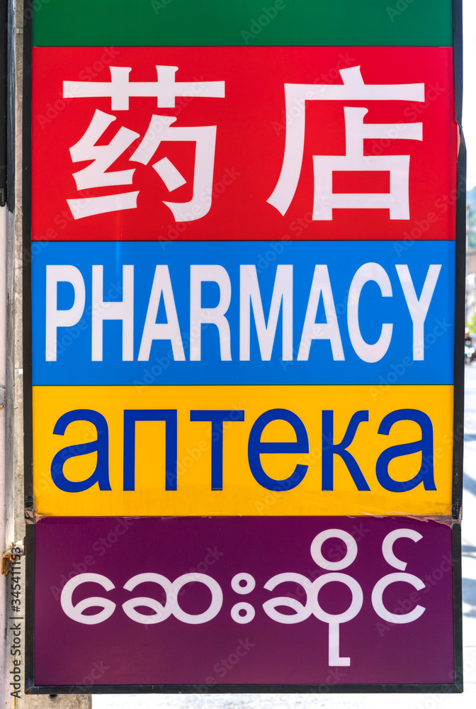 Fototapeta premium Pharmacy sign hanging on a building on the road
