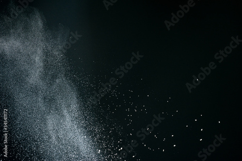 Wonderful pattern of white powder of light snow and flour explodes on black background