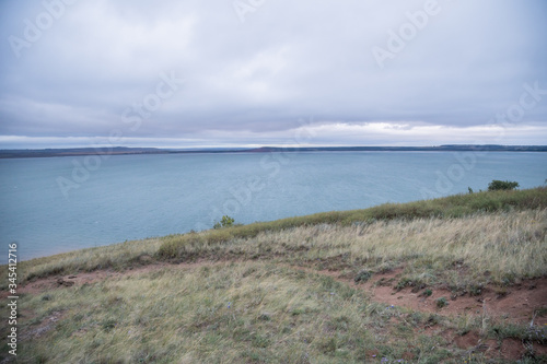 Aslykul - the largest lake in Bashkiria in cloudy weather with gray sky and blue water and a rocky shore