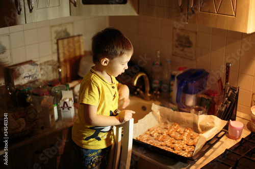 a little boy helps bake cookies