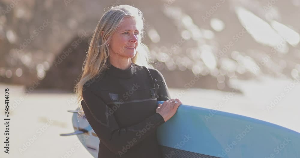 Close up senior beautiful woman holding surfboard at the beach
