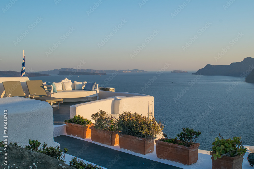 Planters on a white wall on top of the traditional village of Oia in the Greek island of Santorini overlooking at the Aegean sea