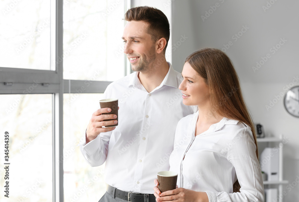 Young colleagues drinking coffee in office Young colleagues drinking coffee in office