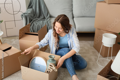Young woman unpacking movin...