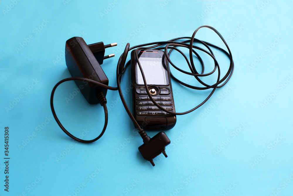 Old, mobile phone with charger, old technology. Old, mobile phone with charger, old technology.