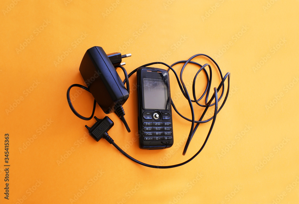 Old, mobile phone with charger, old technology. Old, mobile phone with charger, old technology.