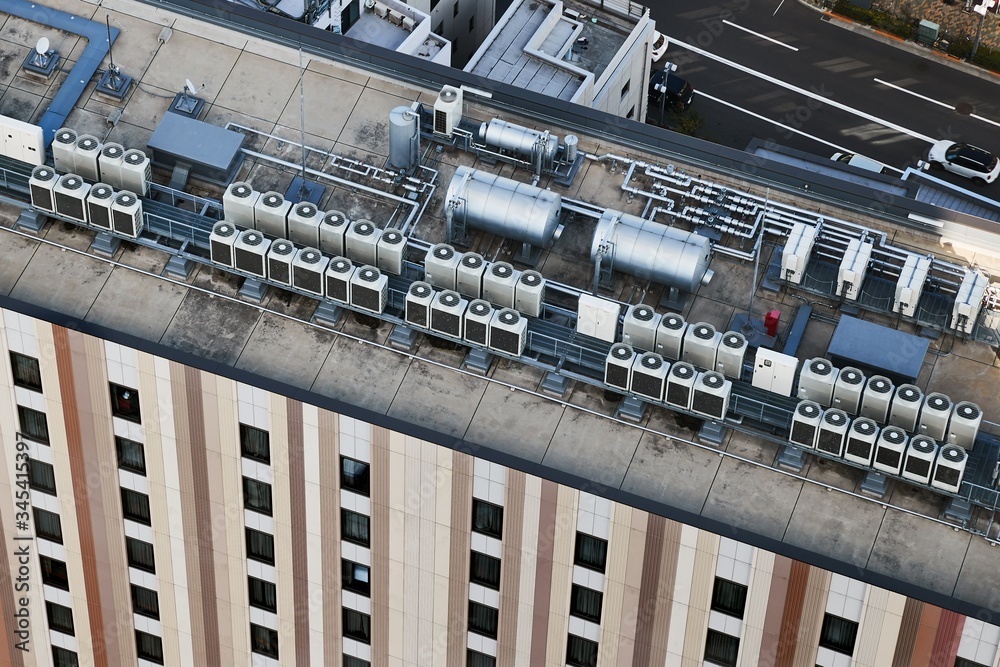Air conditioner heat exchangers on the roof to of a big building, viewed from above