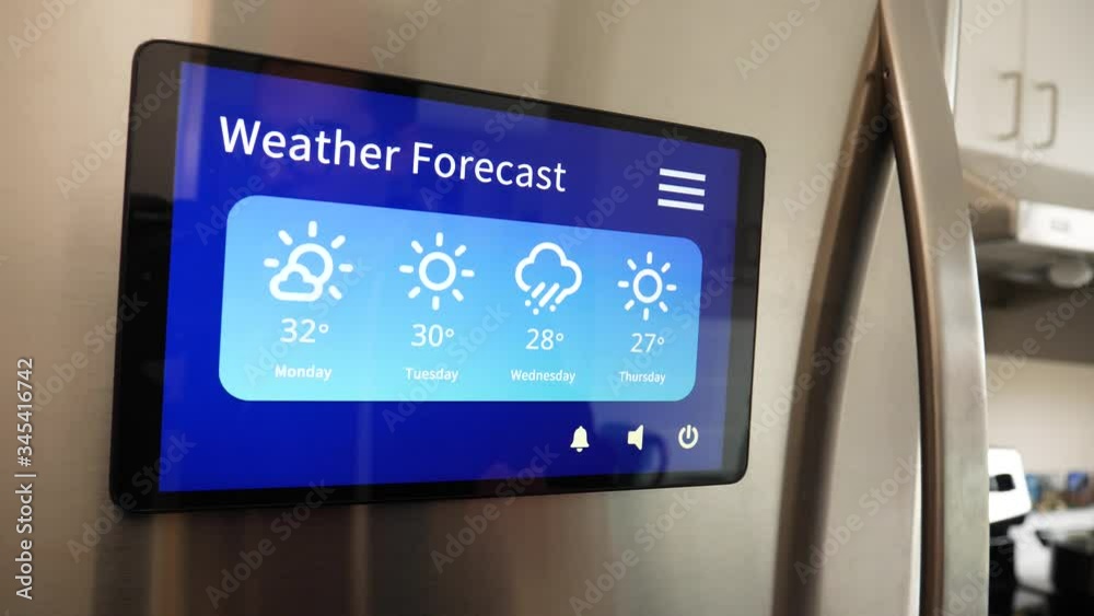 Man using his Smart Refregirator touch screen to see the weather forecast for the week in his kitchen at home Man using his Smart Refregirator touch screen to see the weather forecast for the week in his kitchen at home