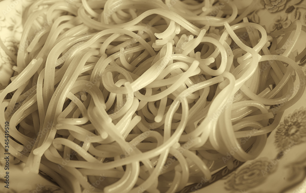 Breakfast at home on the forge. On a plate is vermicelli - Italian spaghetti. Photographed close-up. Color image. Horizontal frame. Black and white image, sepia, soft contrast.