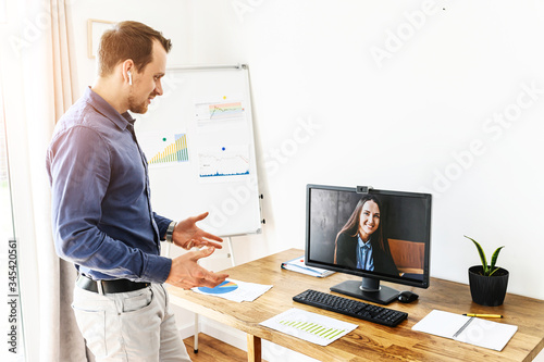 Video meeting of employees. A guy speeches to young woman on pc screen