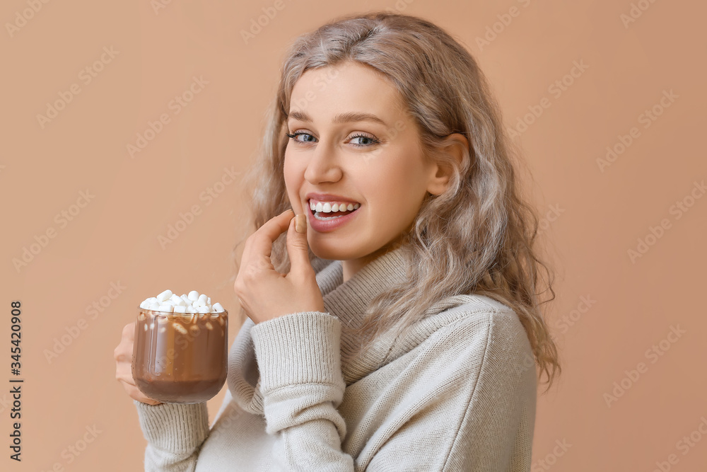Beautiful young woman with cup of hot chocolate on color background Beautiful young woman with cup of hot chocolate on color background