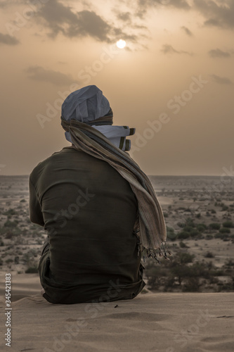 mexican indigenous man sitting in desert of jaisalmer