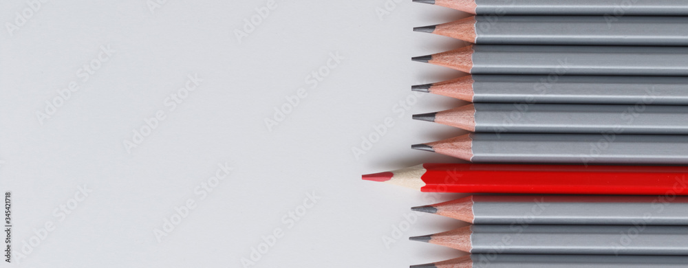 red pencil and gray pencils on a white paper background. red pencil and gray pencils on a white paper background.