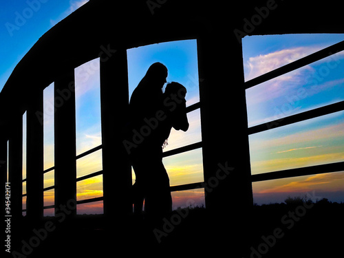 young people watching the sunset from a bridge photo