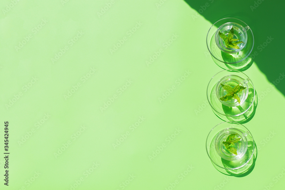 Relaxing mint tea on green background, trendy light and shadow Relaxing mint tea on green background, trendy light and shadow