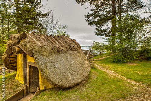 Little Viking pithouse covered with reeds at the Roskilde firth photo