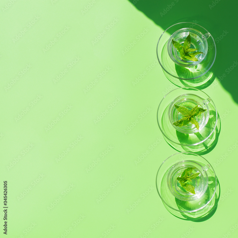 Relaxing mint tea on green background, trendy light and shadow Relaxing mint tea on green background, trendy light and shadow