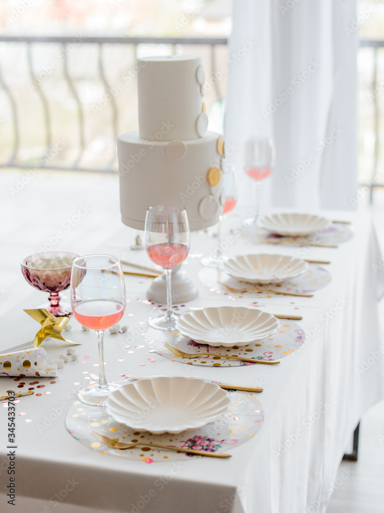 Fototapeta premium Birthday or wedding table setting in white colors with cocktails in glasses. Baby shower or girl party. Selective focus