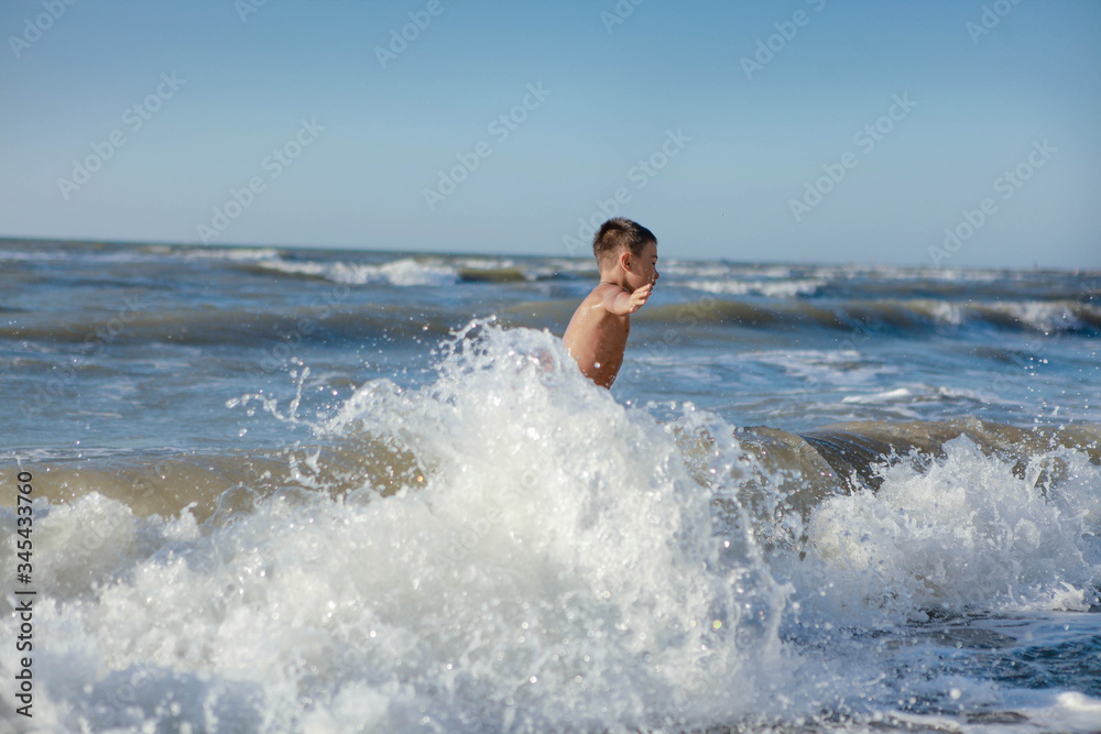Fototapeta premium a child jumps in the waves