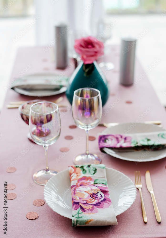 Close up birthday or wedding table setting in pink and colors with fla napkns, golden ccutlery, rose in vase. Baby shower or girl party. Close up birthday or wedding table setting in pink and colors with fla napkns, golden ccutlery, rose in vase. Baby shower or girl party.
