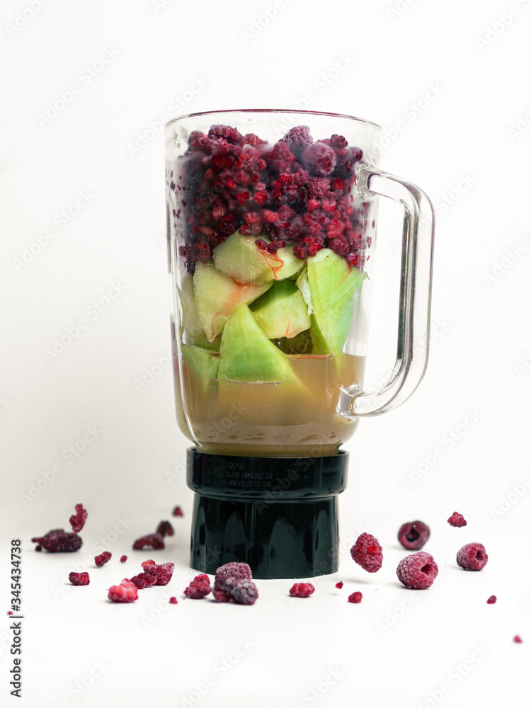 Smoothie Mixer mit verschiedenem Obst und Saft, Bunter Mixer mit Melone,  Himbeeren, Johannisbeeren und Apfelsaft, Himbeeren Fallen ins Glas Stock  Photo | Adobe Stock