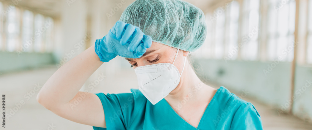 Fototapeta premium Female medical professional feeling tired. Wide format, cinema, panorama, banner