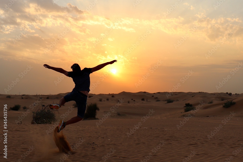 happy young man jumping on the beach at sunset happy young man jumping on the beach at sunset