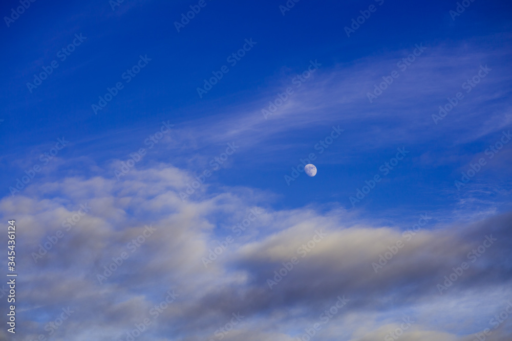 Beautiful waxing gibbous moon and beautiful blue sky and some scattered clouds Beautiful waxing gibbous moon and beautiful blue sky and some scattered clouds