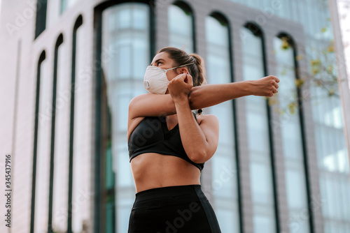 girl does sports with a mask on the street during the confinement of coronavirus