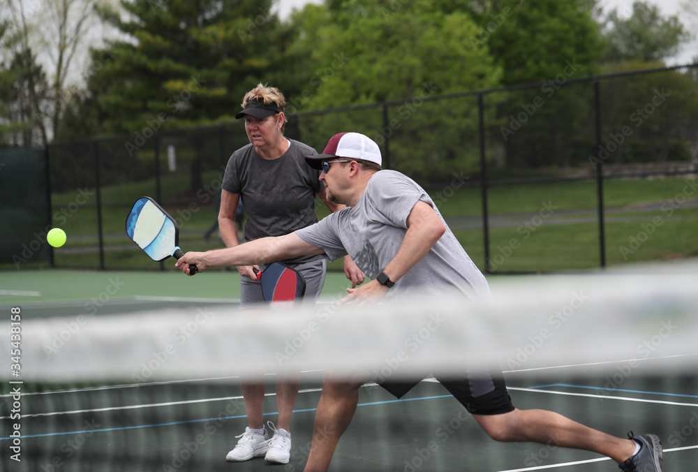 Obraz premium pickleball mixed doubles action 