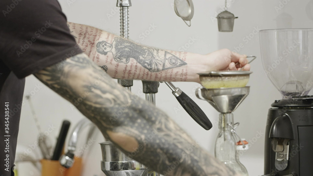 Barista with a tattoo prepares lemon, natural juice in a bottle for making a summer drink. Slow motion, Full HD video, 240fps, 1080p.