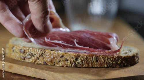 Man making a big sandwich with ham, bread and salad. Nice food video