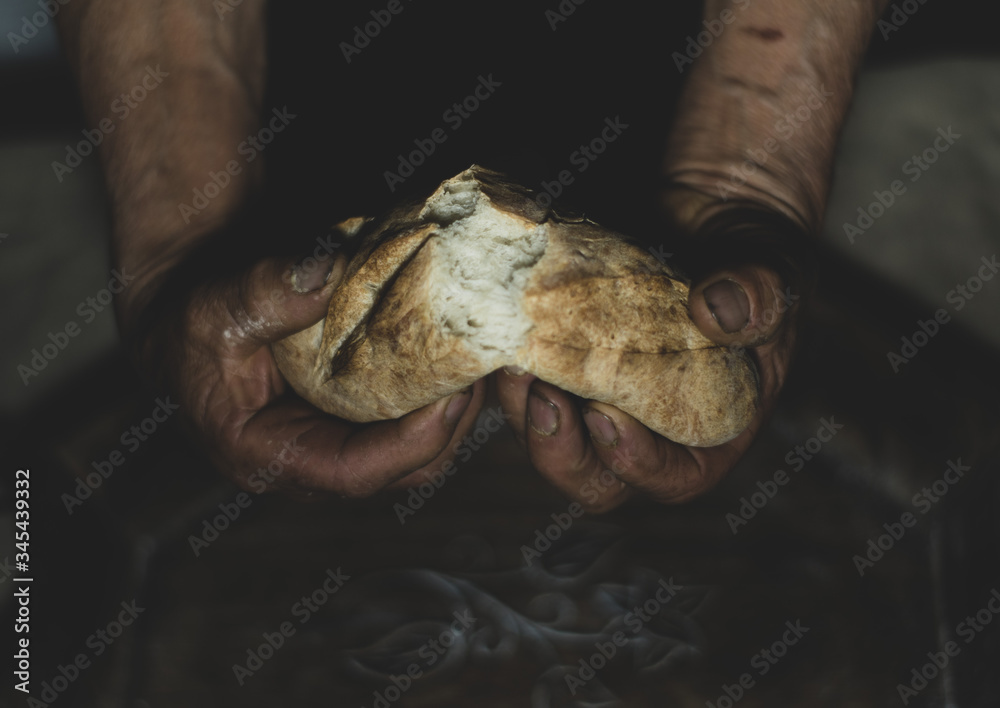 hands of a man breaking bread