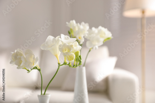 Beautiful white freesia flowers in room, closeup