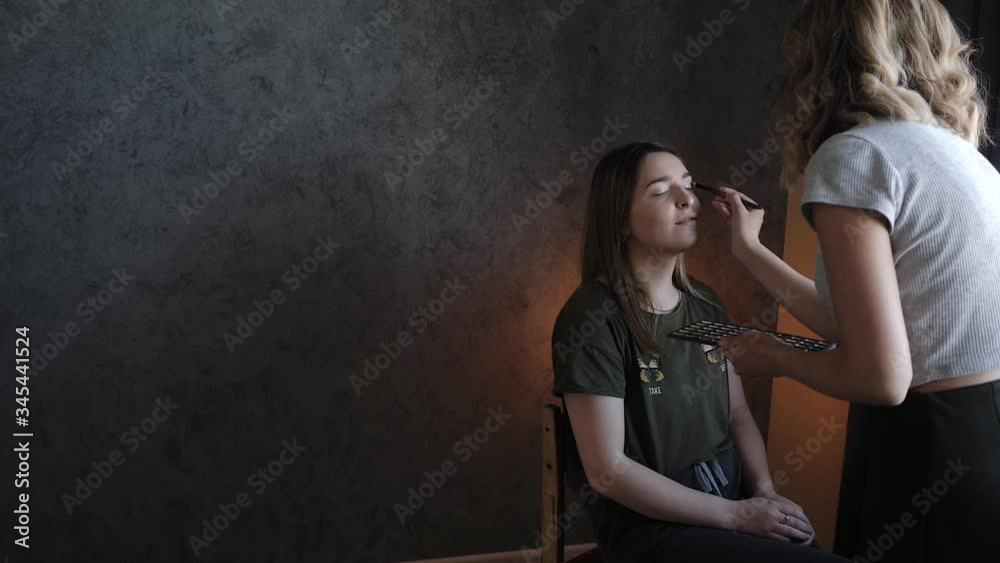 young woman make-up artist doing makeup for the bride young woman make-up artist doing makeup for the bride