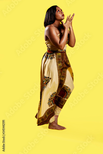 beauty portrait of an African american black woman model with long black flowing hair, smooth skin, elegant eye shadow. yellow background isolation.