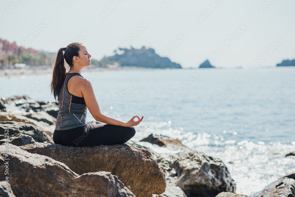 woman doing yoga on the beach