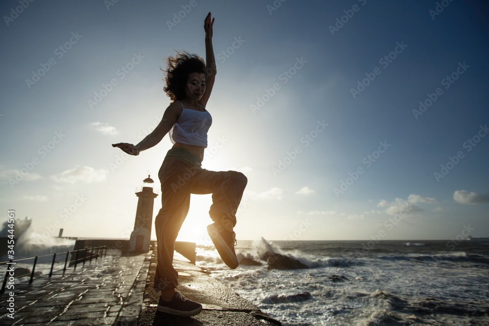 Asian woman having fun and dancing of ocean promenade.