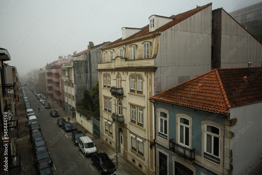 Buildings on the street in foggy weather, Porto, Portugal. Buildings on the street in foggy weather, Porto, Portugal.