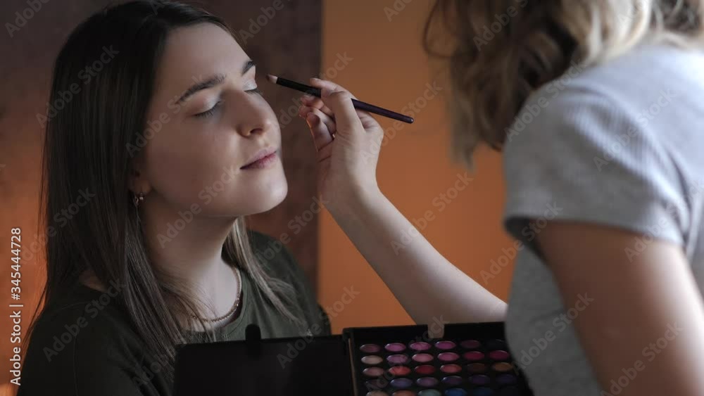 young woman make-up artist doing makeup for the bride young woman make-up artist doing makeup for the bride